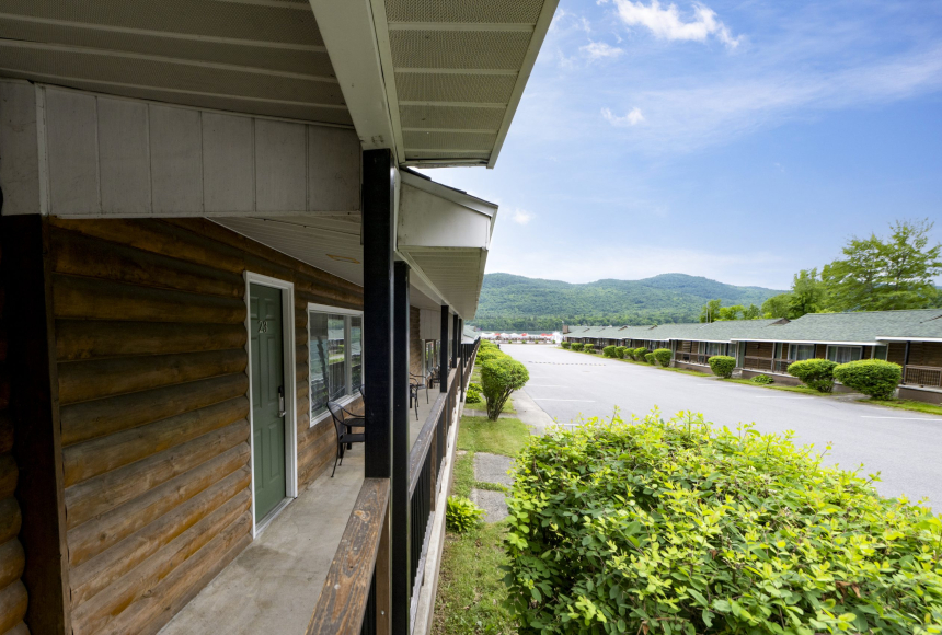 A log cabin style building with a covered porch and a mountain view.